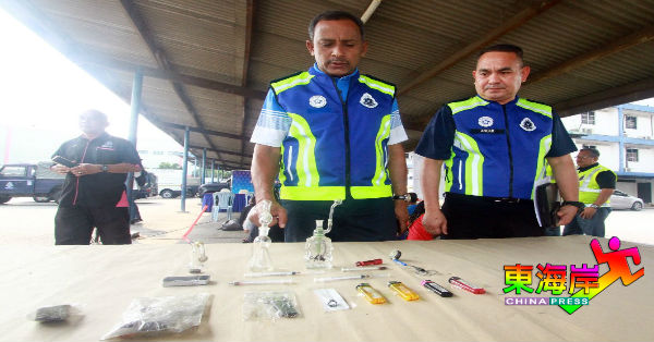 莫哈末诺（左）及安努亚检视被起获的吸毒器具。
