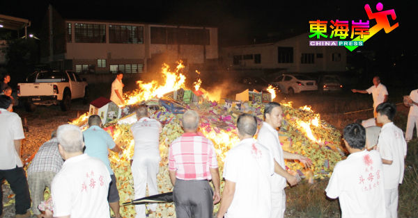 关丹斗母宫坛前组、理事会成员及信众配合普度法会仪式，焚烧丰富的纸扎供品。
