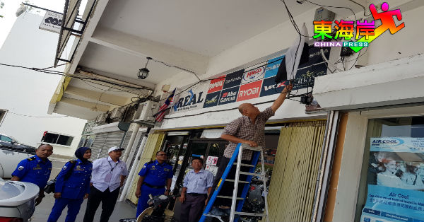 商家将已纠正“白黑”位置的彭亨州旗重新挂在店前。