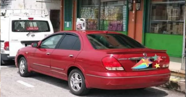 轿车顶上置放有“卖车”涵意的旧机油瓶，被执法人员开出罚单。