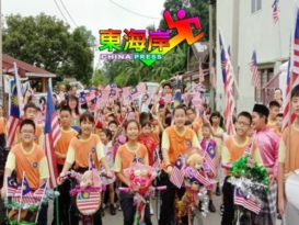 立卑槟绒华校  师生持国旗绕新村