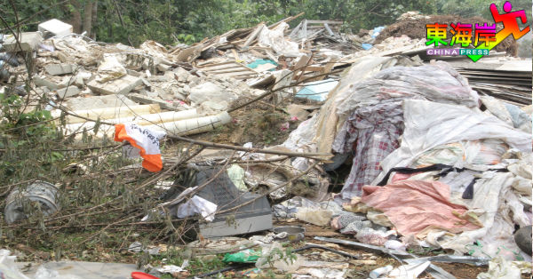 建筑废料及塑料品堆积在非法垃圾场周遭。