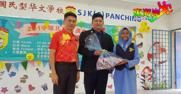 宋梓良（左）陪同张赈琮，颁发比赛冠军奖予获奖队伍代表阿努。