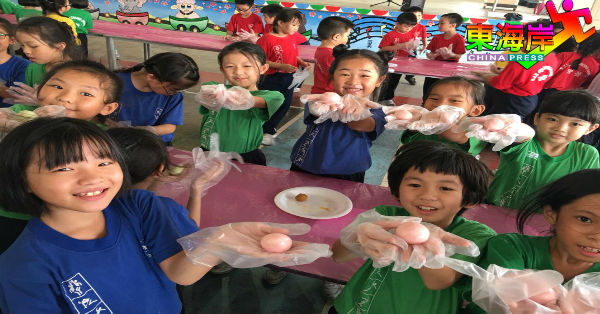 关丹中菁二校学生们开心展示亲手制作的月饼。