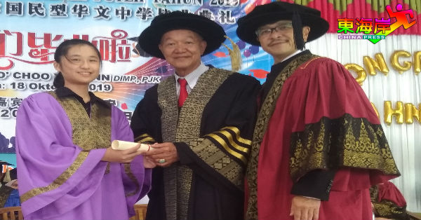中五毕业生代表从朱源安（中）手中领取毕业证书，右为校长陈国辉。
