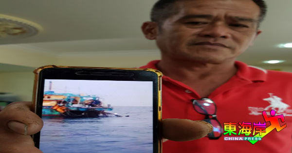 陈伟光展示渔民凭拍下渔网卡树叶的照片，指控他撞毁礁石和索偿。