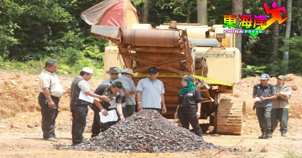 森林局官员在其中一个非法金矿中，检查被挖掘矿石。