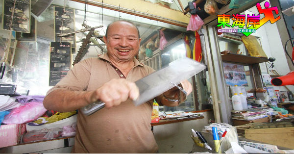 古杏明展示锋利的大菜刀，也可发挥“削纸如泥”功效。