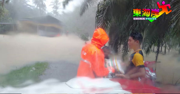 国能计电员冒雨为登州士兆甘榜达遥水灾灾黎，送上白米等援助品。
