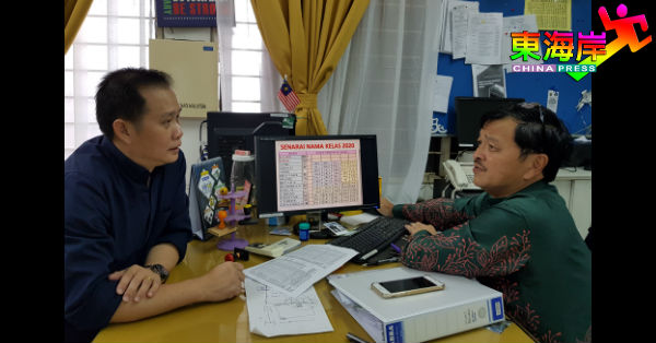 家协主席张翔坚（左）向陈国辉了解“老师定点班”授课室分配内容。