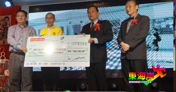 蔡世才（左3）移交50万的模拟支票，作为关丹中华中学的行政开销，由校长蔡若峰代领（左），左2起黄道坚及蔡世贤。