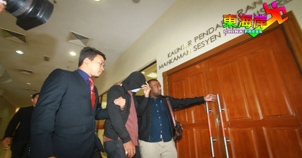 沙林沙法米（中）被反贪会官员押送到法庭面控。