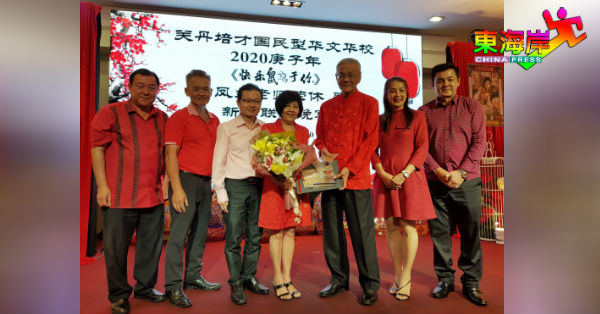 曾再明（左5）赠送鲜花牌匾予荣休老师叶凤兰，由吴英莱（左起）、潘先煌、邱瑞福、李妮达及拿督陈智耀陪同。