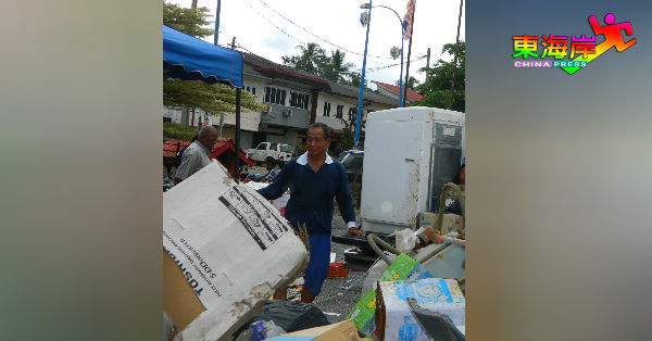 男志工驾车协助载垃圾回到收集站。