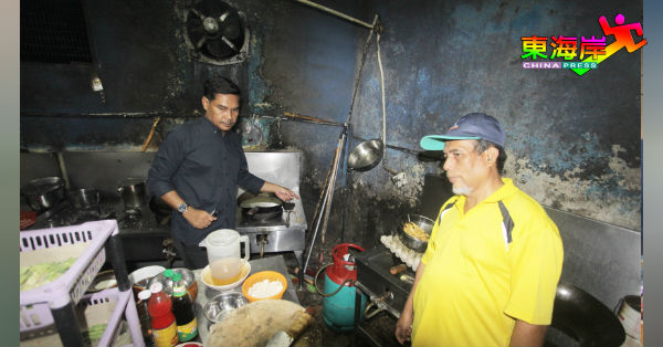 韩丹（左）不满餐馆简陋的餐馆厨房，完全没有厨余排污系统，右为商业执照组主任阿历斯亚。