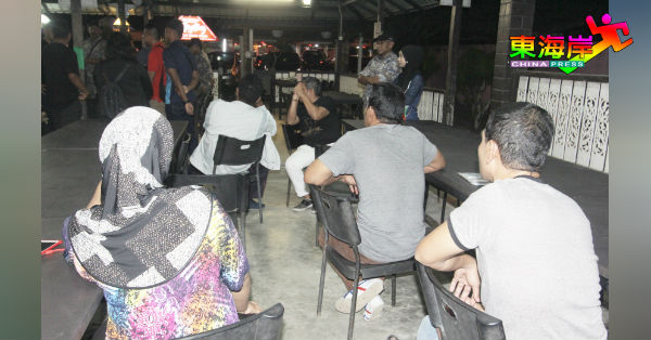 东炎餐馆内非法打工的泰籍男女“游客”，被令静坐一旁等待处置。