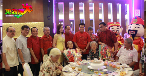 叶运兴（站者右）赠送保健礼篮给最年长的男女会员郑泰昌（89岁）及黎秋莲（93岁）。