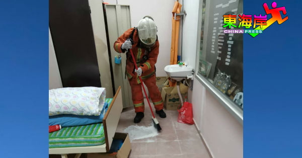 全幅防化学品装备的消拯员小心翼翼地将沾粉水银清扫干净。