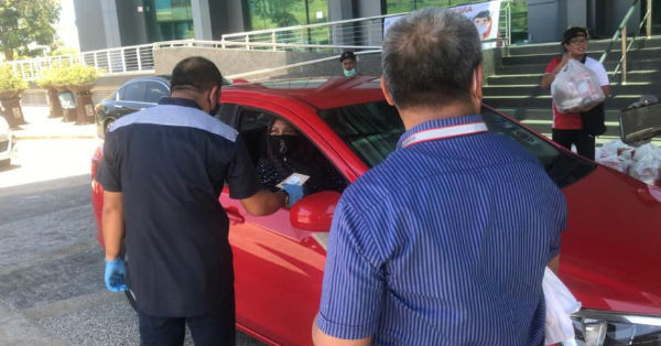 关丹市议会人员把物资放到小贩的车上。