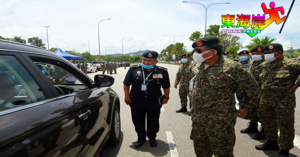 哈斯布拉（右起）在阿都加里尔陪同下，在军警路障处与民众互动。