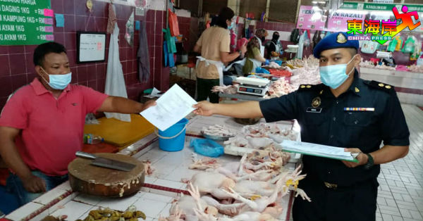 彭州贸消局执人员将佳节统制品顶价表派发予关丹大巴刹肉鸡贩。