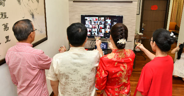 黄瀞慧（左4）与丈夫廖钦泉及一对新人向萤幕上的亲朋戚友敬酒。 （受访者提供）