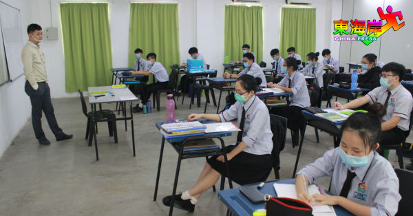 学生都戴上口罩在桌椅前后左右摆放1公尺距离下复课。