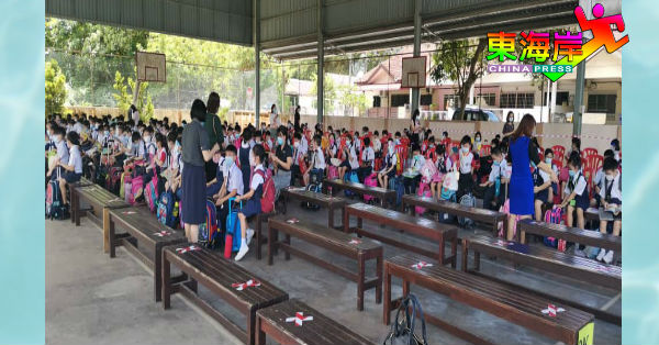 关丹培才华校下午班的低年级学生被安排在雨盖篮球场等候进入课室。