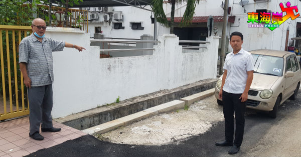 陈俊广（右）向潘延华了解住宅区道路和沟渠维修情况。