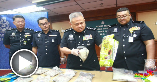 阿都加里尔（左3）展示警方在铁观音包装，发现的毒品。