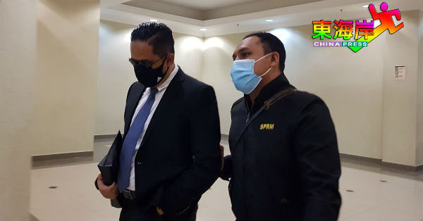 被告莫哈末法兹鲁阿兹林（左）否认5项收贿罪名后，由反贪会官员带离法庭。