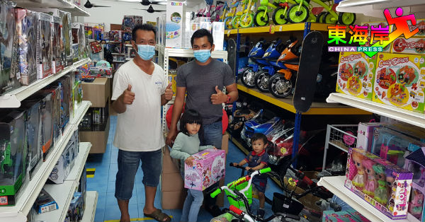 客户凯里携同孩子挑选脚踏车，获店主黄志强（左）接待。