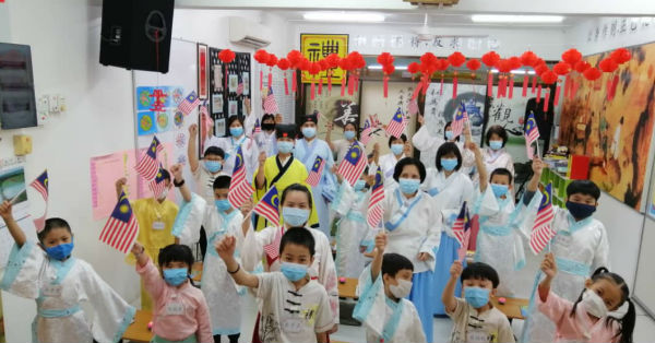 彭亨关丹圣贤教育中心老师、家长及学生，挥动国旗庆祝国庆日。