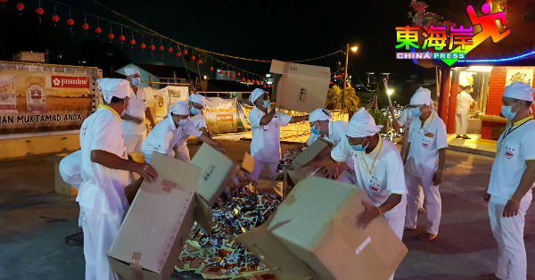 关丹斗母宫坛前组组员将善信大众报名的纸片“金童玉女”，一箱箱地倒放在焚化架上。