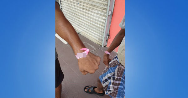 两名相信是餐馆店员的男子手戴着粉红色隔离手环，出现在店前。
