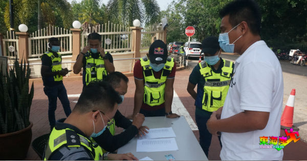 ”抢救猫山王联盟“副主席方文龙（右）出示身分证，让警员核对。