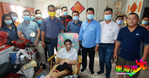蔡永祥（左7）率同关丹慈善家理事成员慰问陈诗杰，右为患者父亲陈金山。