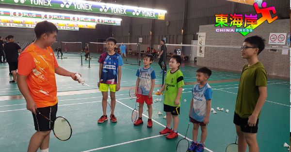 前国手男单兼KYK羽球训练学院教练陈德汉（左）指导小球员羽球技术知识。