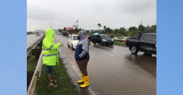 受困的司机们被迫在路旁等待积水消退。