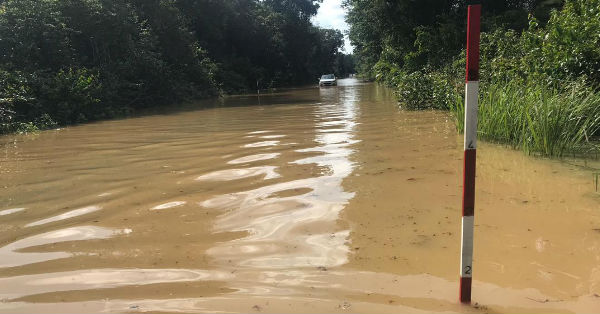 车辆在内陆道路遭积水淹没后，仍冒险“涉及”而过。