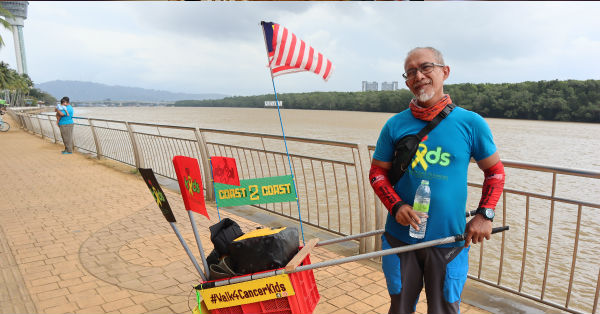 穆克利斯推着小型手推车及携带“癌童家长及支援协会”（KIDS）旗帜达到关丹河畔公园，完成徒步竞走行动。