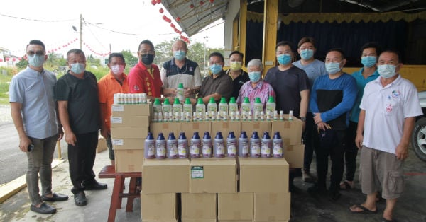 陈贵龙（左4）在众人见证下移交清洁用品予斯里再也灾民，由黄养德接领。