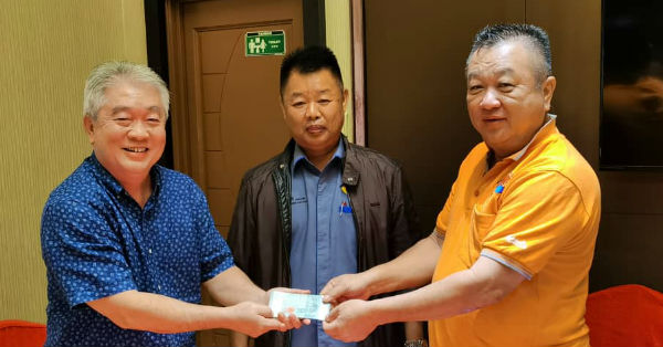 关金荣（左）移交支持水灾赈灾行动“一日一盒饭”3000令吉予梁永康，由蔡永祥（中）见证。
