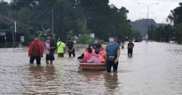 甘马挽华社水灾援助队以纤维船将受灾华裔灾黎送离灾区。