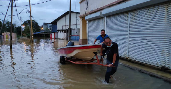 甘马挽华社水灾援助队队员将纤维船送往灾区，准备展开救灾工作。
