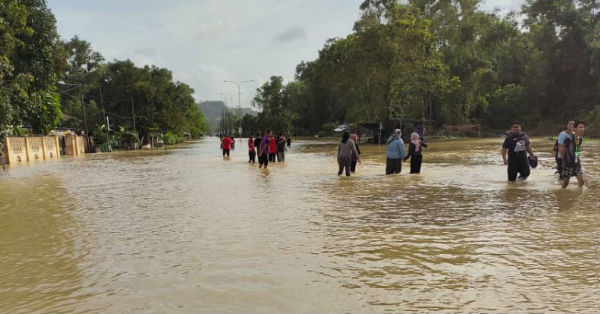 灾区变泽国中断道路后，居民不惜冒险涉水而行。