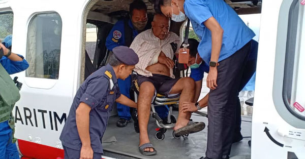 因手骨折及行动不便的男伤者拉欣沙丹（中）在医务人员及飞行员协助下，准备下机送院治疗。