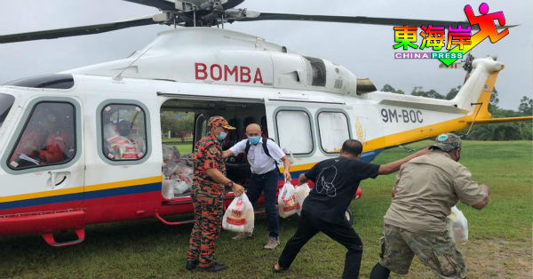 沙烈胡丁（左2）随同消拯局直升机前往乌鲁淡比灵，参与空军粮食赈灾品行动。
