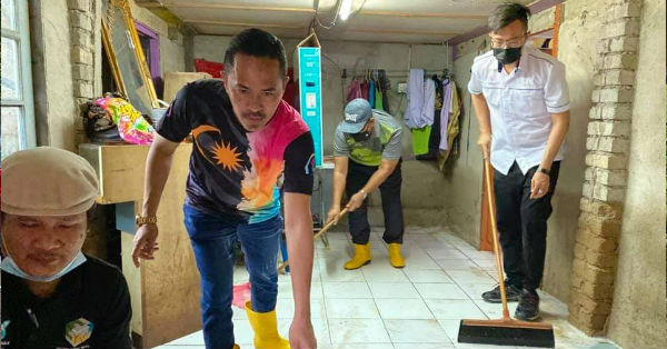 谢东成（右）及义工们合力清洗受灾住家，为年迈居民解困。