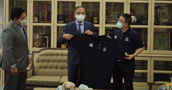 胡玖林（右）将彭州政府水灾特别援助基金志愿团T恤制服移交给旺罗斯迪。